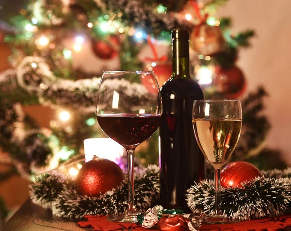 Vasos con vino delante de un árbol de Navidad iluminado —  Fotos de Stock