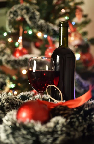 Γυαλιά με κρασί μπροστά από ένα φωτισμένο χριστουγεννιάτικο δέντρο — Φωτογραφία Αρχείου