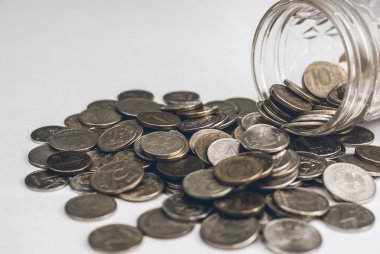 Cam bir kavanoz para çıktı. Ahşap arka plan üzerinde paralar.