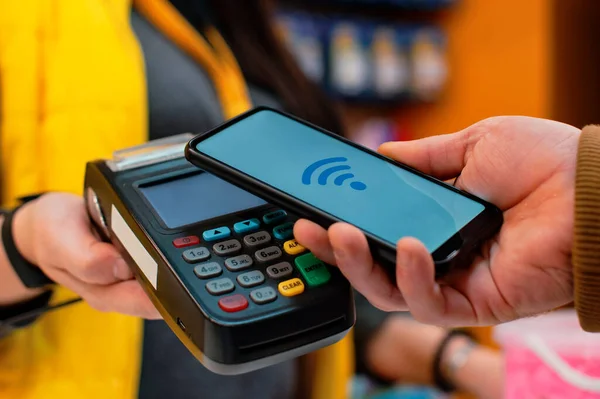 Klient Płaci Smartfonem Sklepie Przy Użyciu Technologii Nfc Tle Terminalu — Zdjęcie stockowe