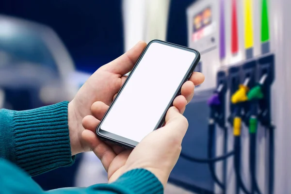 Bir benzin istasyonunun arka planına yakın plan akıllı telefon numarası yap. Ödeme yakıtı çevrimiçi