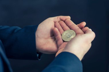 Sanal para birimi ve engelleme zinciri kavramı. Elinde Bitcoin tutan mavi ceketli bir iş adamı.