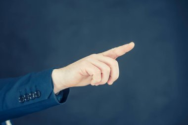 Gömlekli ve mavi ceketli bir işadamı elleriyle el hareketlerini gösteriyor.