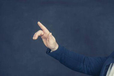 Gömlekli ve mavi ceketli bir işadamı elleriyle el hareketlerini gösteriyor.