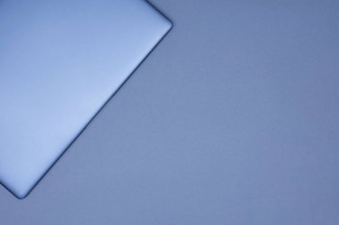 Gri bir arkaplanda gümüş bir dizüstü bilgisayar. Üst görünüm