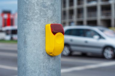 Otomobilli bir yolun arka planındaki yayalar için trafik lambasındaki sarı düğme