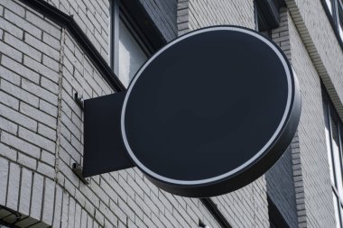 Evin arka planında açık hava reklamı için yuvarlak bir sokak tabelası.