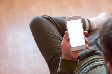 Adam elinde beyaz bir ekranla akıllı telefonun maketini tutuyor.