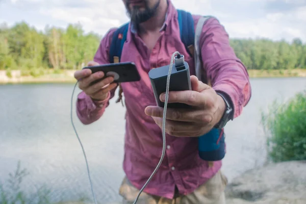 Killen Håller Bärbar Laddare Med Smartphone Handen Människan Bakgrund Naturen — Stockfoto