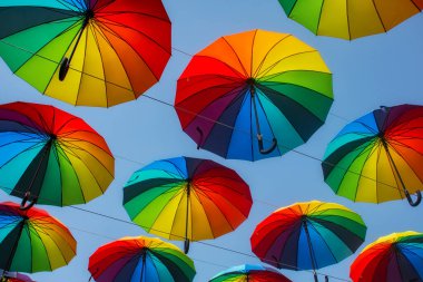 Gökkuşağı çok renkli şemsiyeler Gökyüzünün arka planında yağmurdan