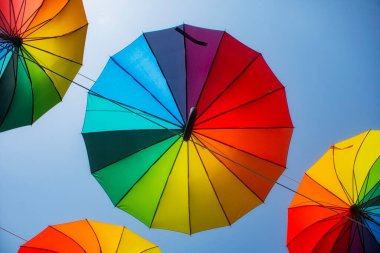 Gökkuşağı çok renkli şemsiyeler Gökyüzünün arka planında yağmurdan