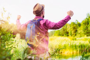 Bir turist seyahat için sırt çantasıyla gölün kıyısında duruyor. Turizm konsepti