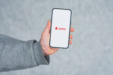 Akıllı telefon ekranındaki internet kanalına abone ol. Adam akıllı telefonu simgeyle yakın plan çekiyor