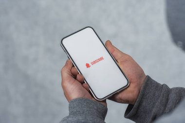 Akıllı telefon ekranındaki internet kanalına abone ol. Adam akıllı telefonu simgeyle yakın plan çekiyor