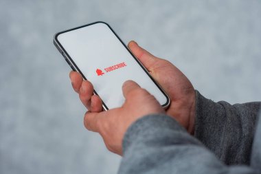 Akıllı telefon ekranındaki internet kanalına abone ol. Adam akıllı telefonu simgeyle yakın plan çekiyor