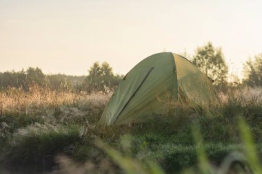 Doğanın arka planında gün doğumunda turist çadırı