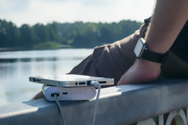 Een Man Laadt Een Smartphone Met Een Powerbank Een Houten — Stockfoto