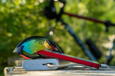 Akıllı telefon taşınabilir şarj aleti ile şarj edilir. Ormandaki elektrik bankası bir bisikletin arka planında