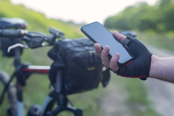 Radfahrer Hält Smartphone Nahaufnahme Der Hand Auf Dem Hintergrund Eines — Stockfoto