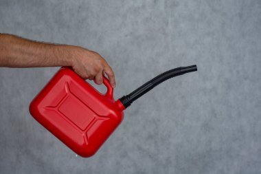 Adamın elinde kırmızı plastik bir gaz tüpü var.