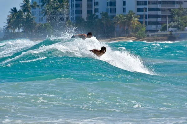 Les surfeurs chevauchent les vagues sur la plage de Condado — Photo