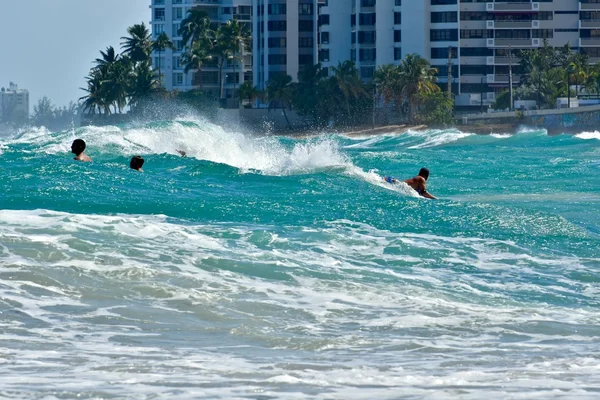 Les surfeurs chevauchent les vagues sur la plage de Condado — Photo