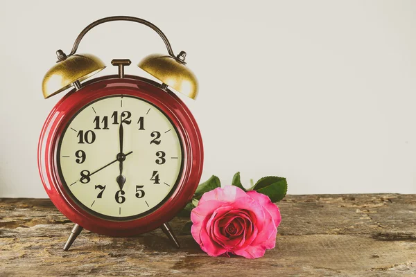Retro çalar saat ve ahşap üzerine pembe Gül