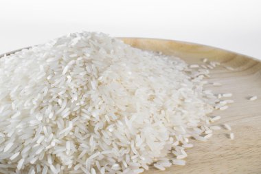 Pişmemiş pirinç taneleri ahşap plakalar üzerinde.