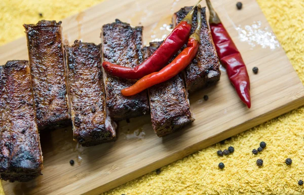 Grilled pork ribs with red pepper on the board — Stock Photo, Image
