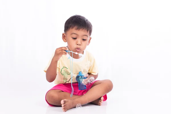 Гострий маленький хлопчик дме бульбашку — стокове фото