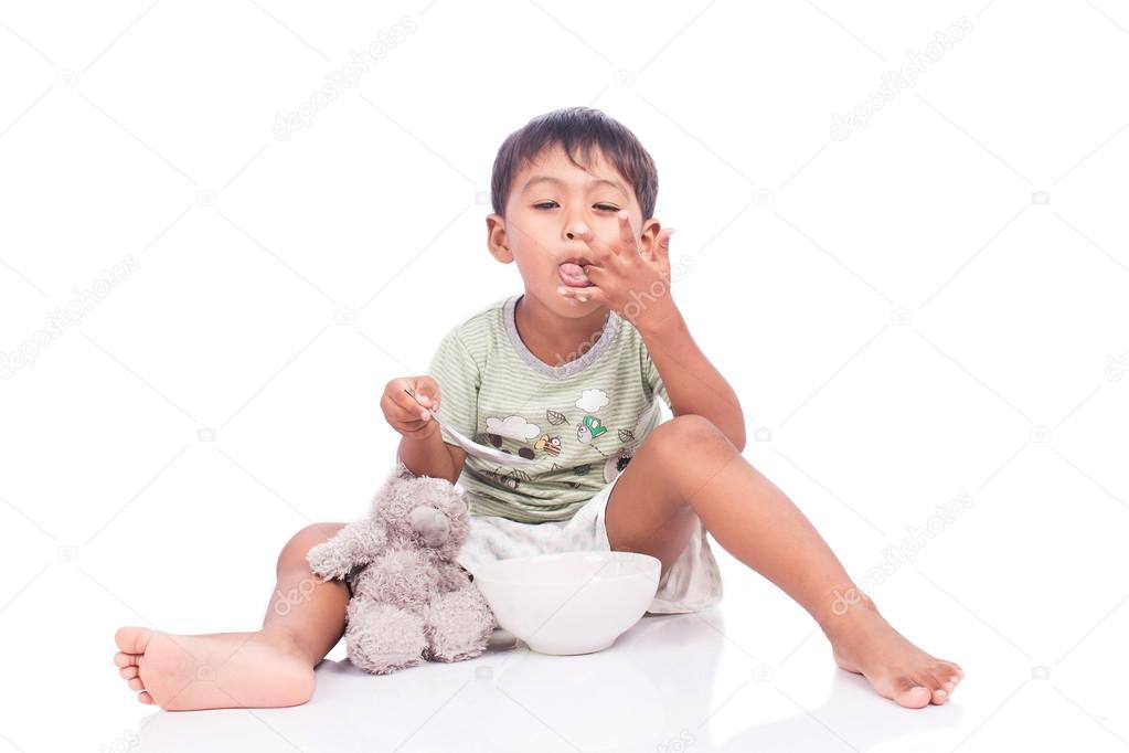 cute little boy licking fingers while eating sweets,focus finger