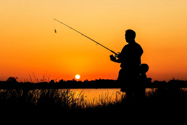 Pai e filho pesca no rio pôr do sol backgrond — Fotografia de Stock