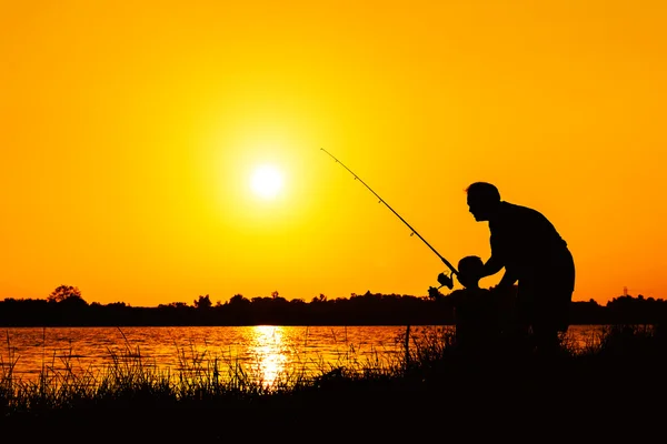 Pai e filho pesca no rio pôr do sol backgrond — Fotografia de Stock