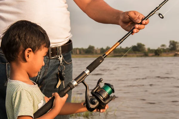 son and dad fishing at river