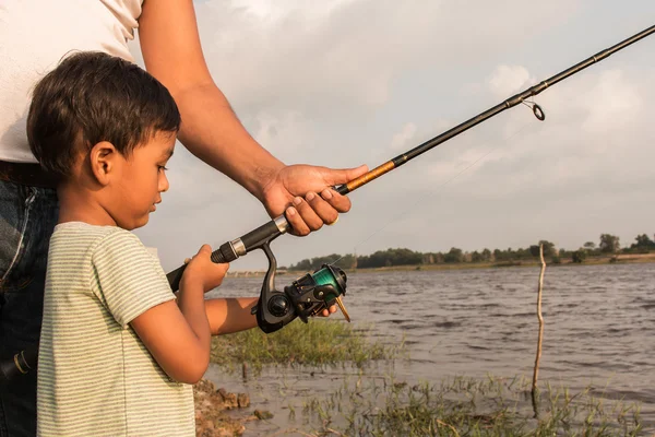 son and dad fishing at river