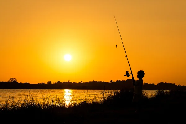 Horgászat a folyó naplemente háttérben kisfiú — Stock Fotó