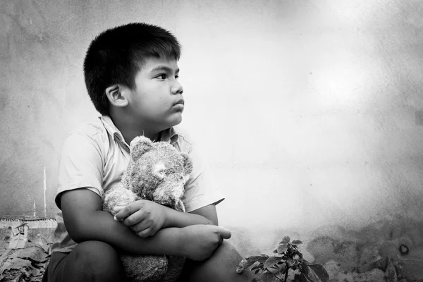 Θλιβερή αγόρι κάθεται μόνος με παλιά τόνο αρκουδάκι, μαύρο και άσπρο — Φωτογραφία Αρχείου