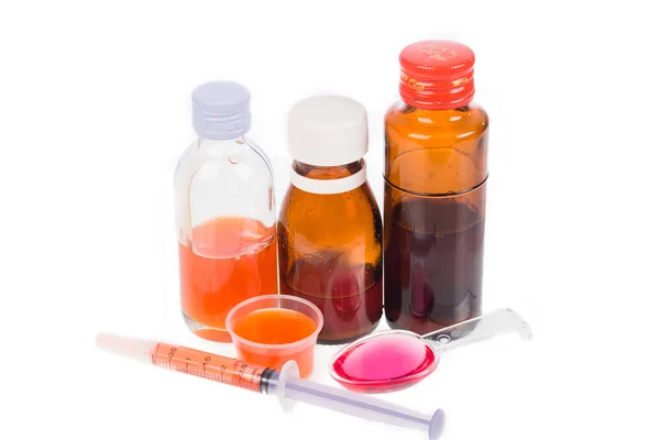 Jarabe Medicamentos Botellas y medicamentos en cucharas sobre fondo blanco —  Fotos de Stock