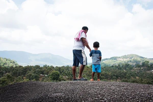 Отец и сын стоят на вершине горы — стоковое фото