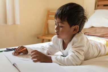 beyaz kitap odasında küçük Asya çocuk boya