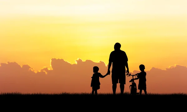 Силует батька і хлопчика стоїть на фоні заходу сонця — стокове фото
