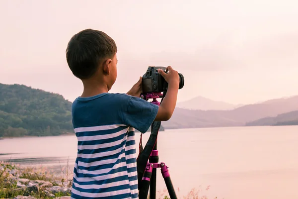 Lindo niño tomando cámara en presa, vendimia, mano de enfoque —  Fotos de Stock