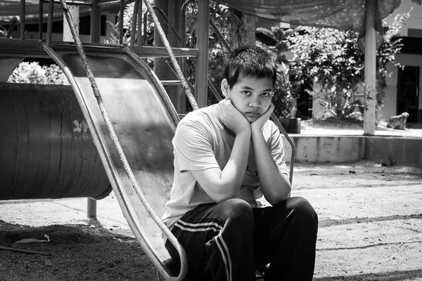 Menina pauper sentado sozinho no playground, tom preto e branco — Fotografia de Stock