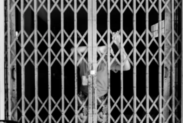 Borrão de menina triste de pé sozinho atrás da cadeia, preto e branco — Fotografia de Stock