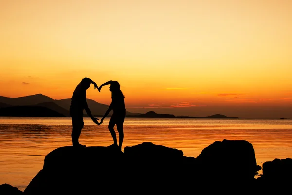 Sylwetka Młoda para w miłości na plaży, tło zachód słońca — Zdjęcie stockowe