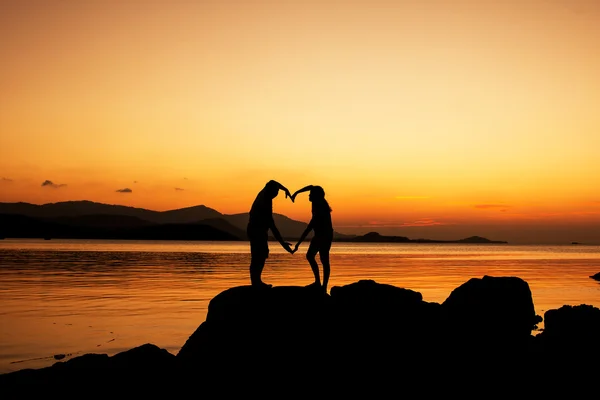 Silueta de pareja joven enamorada en la playa, fondo del atardecer —  Fotos de Stock