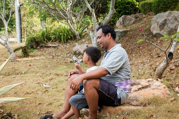 Père jouant du savon à bulles avec son fils dans le parc — Photo