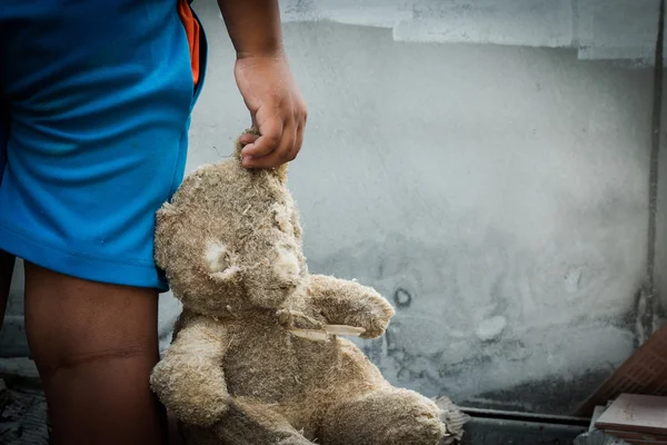 Povero bambino che tiene un orsacchiotto — Foto Stock