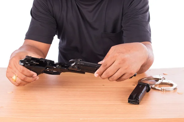 Young man disassembled gun on table