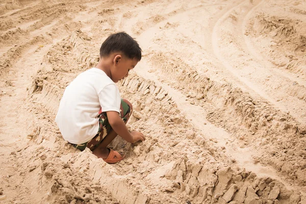 Милый мальчик играет в песок — стоковое фото